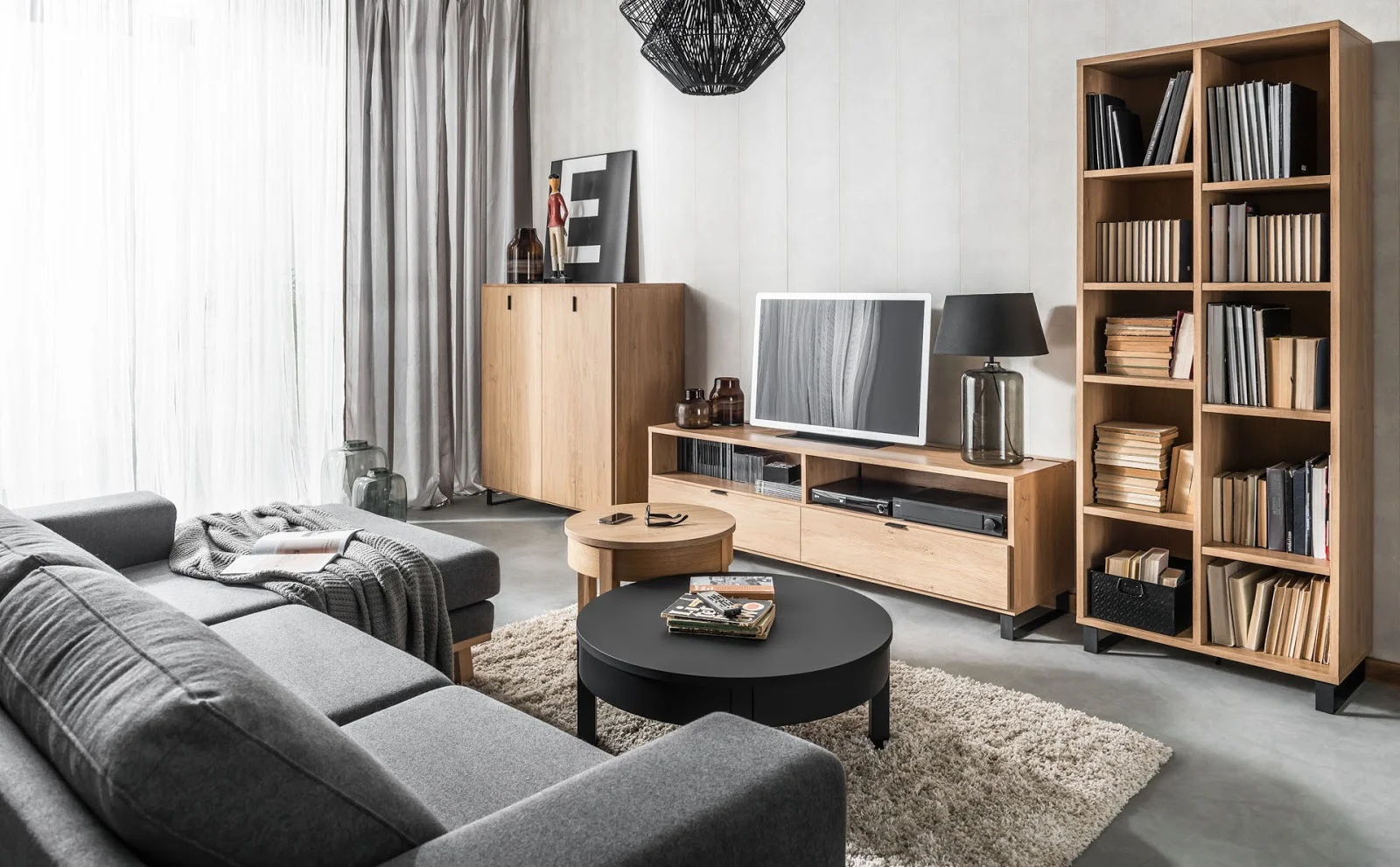 Stylowy salon z drewnianymi akcentami, dużą sofą i telewizorem.